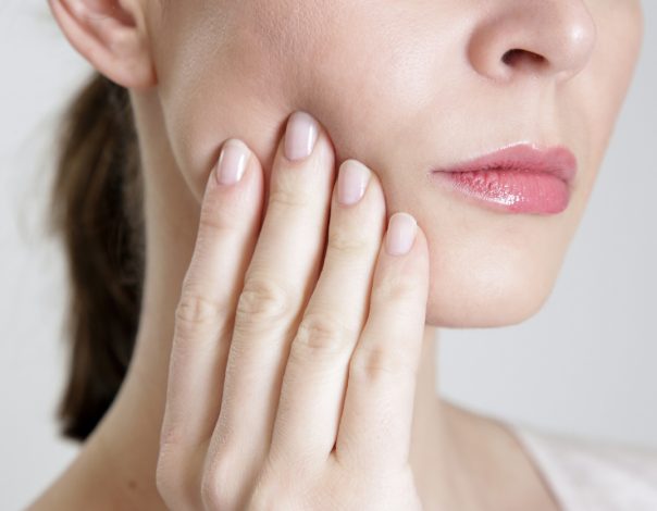 Woman touching her jaw in pain